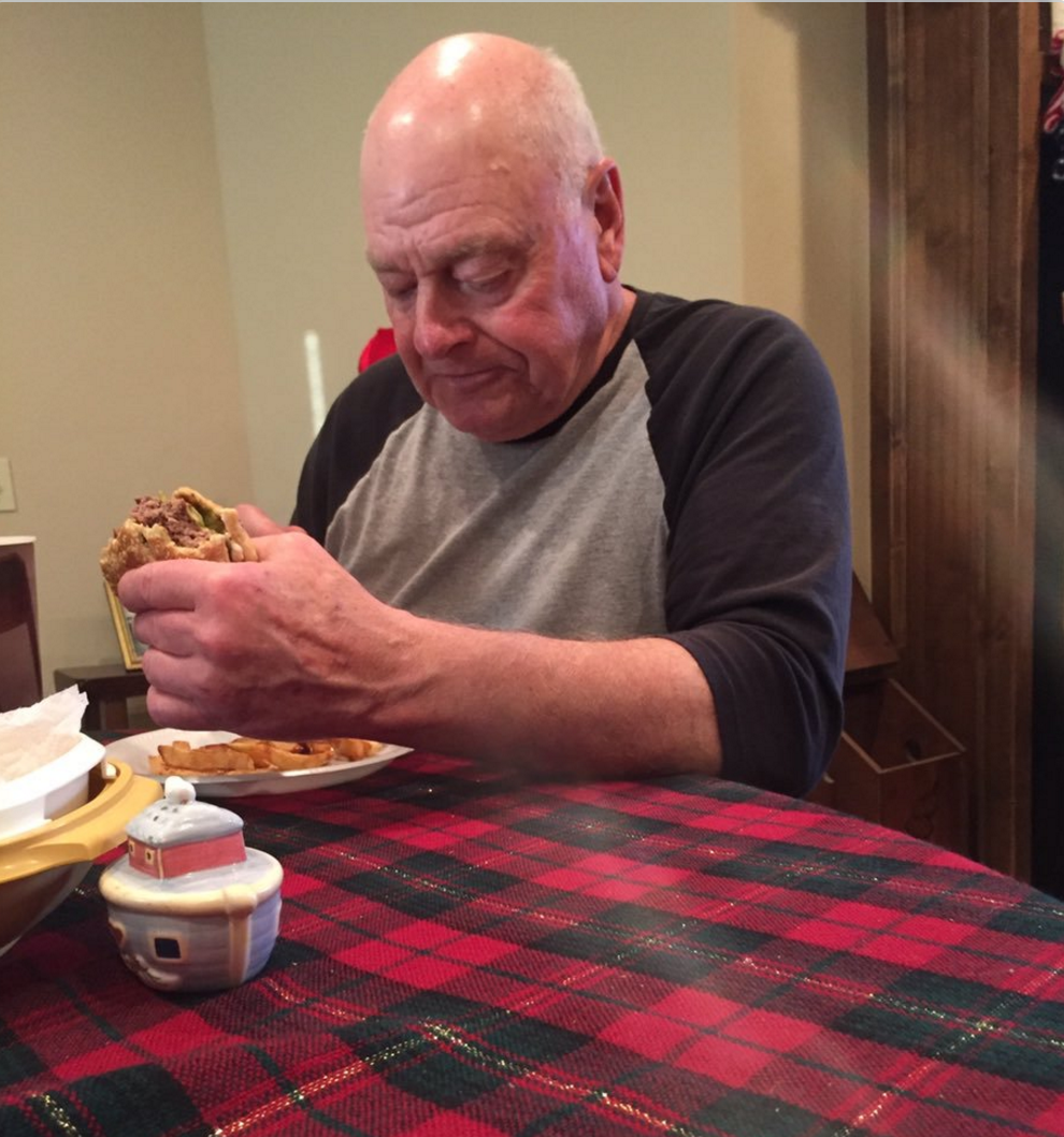 papaw eating a hamburger alone